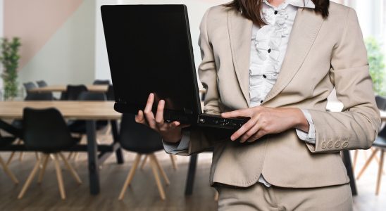 femme en tailleur beige avec ordinateur portable