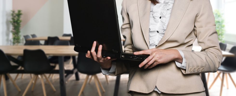 femme en tailleur beige avec ordinateur portable
